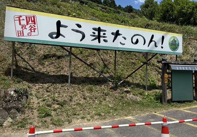 駐車場に設置されている、よう来たのん!と書いてある看板