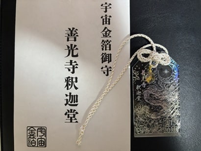 透明なアクリル板に龍や善光寺釈迦堂のイラストが入っている宇宙金箔御守