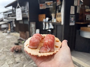 せんべいの上に乗った2つの肉寿司