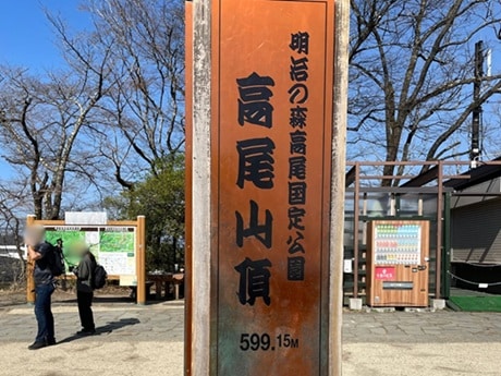 山頂に立つ高尾山頂の看板