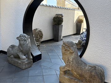 神戸・坂の上の異人館の庭にある2匹の狛犬。間を通り抜けると愛情に恵まれるといわれるLOVEパワースポット