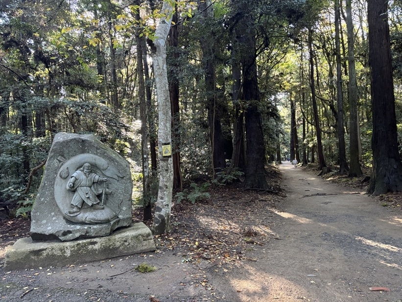 要石へ進む参道にある石碑。神様が鯰の頭を押さえている。