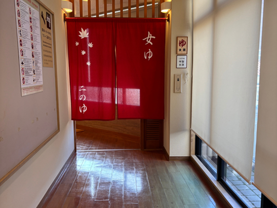 金の湯の女湯入り口（赤い暖簾）